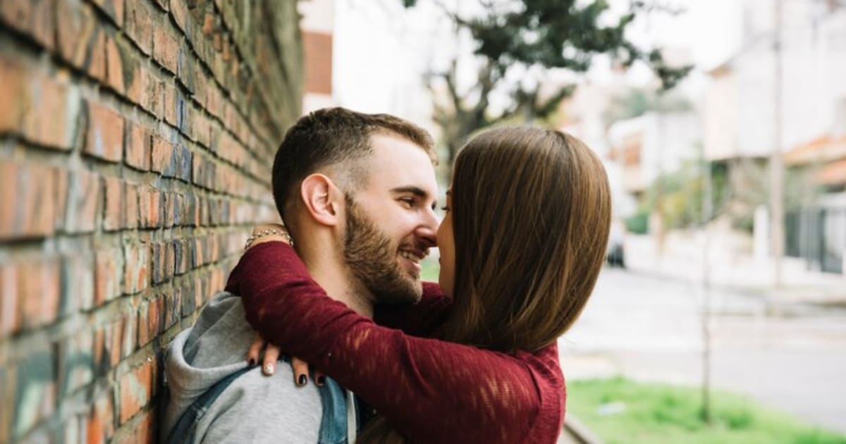 Casal apaixonado se beija encostado no muro após refletirem sobre o tema: Sexo Faz Bem: Descubra Exatamente o Que Ele Pode Fazer na Sua Vida e Saúde.